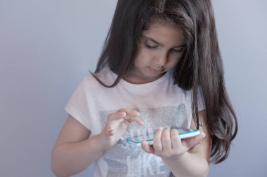 Akıllı telefon kullanan küçük kız. 