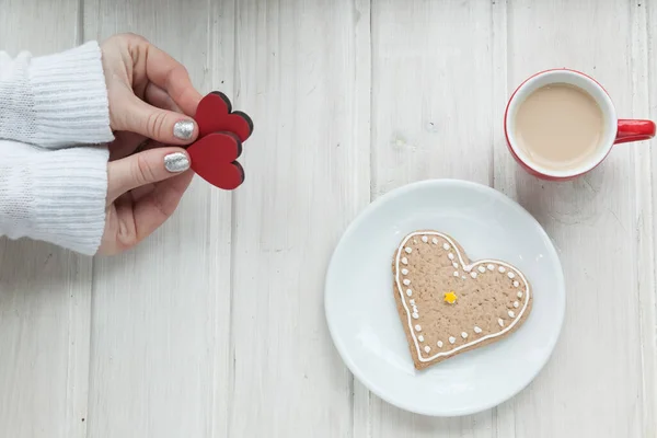 cup of coffee and heart shape on wooden background