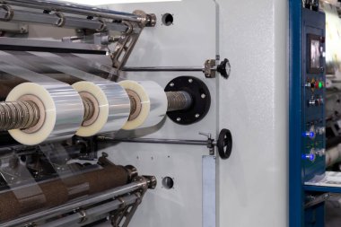 Gıda ürünleri fabrikasındaki otomatik paketleme makinesinde plastik ambalaj filmi. sanayi ve teknoloji kavramı. 