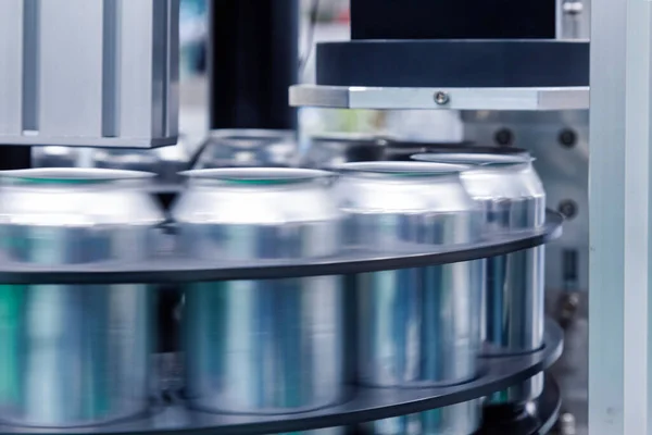 empty new aluminum cans for drink process are moving in factory line on conveyor belt machine at beverage manufacturing. food and beverage industrial business concept.