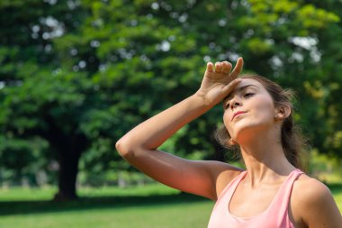 Yaz sabahı parkta koştuktan sonra yorgun atletik genç dinleniyor. İnsanlar ve sağlıklı yaşam tarzı kavramı.