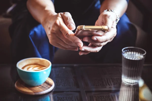 İş adamı akıllı telefonu yatırım haberleri okumak ve e-postaları cevaplamak için kullanıyor. Adam pazartesi sabahı işe gitmeden önce latte kahve içiyor. Klasik fotoğraf ve film tarzı