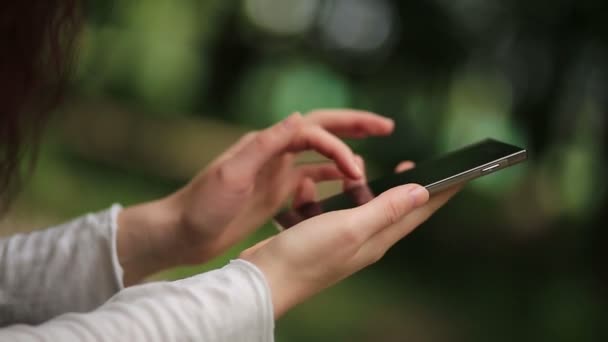 Femme utilise smartphone en plein air