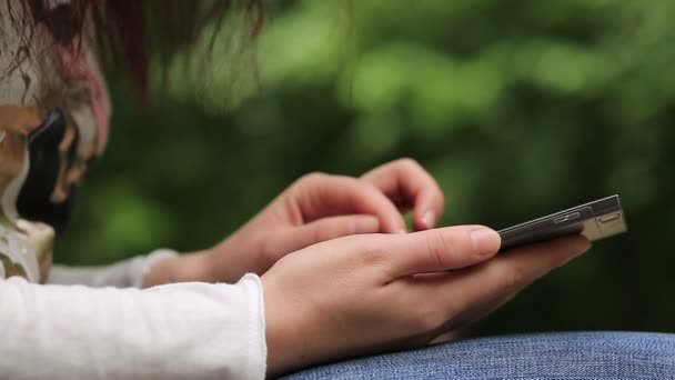 Woman uses smartphone outdoors — Stock Video