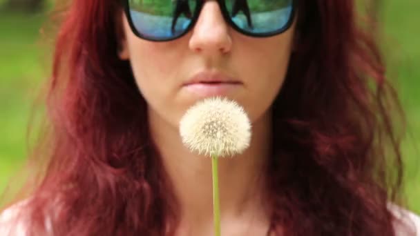 Woman blows dandelion seeds — Stock Video