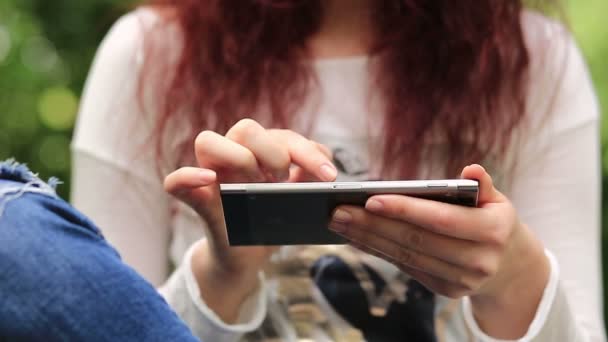 Mujer utiliza teléfono inteligente al aire libre — Vídeo de stock