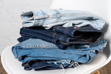 close up view of various jeans stacked on chair clipart