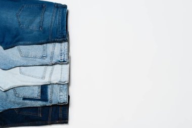 Fotokopi alanı olan beyaz arkaplandaki çeşitli mavi pantolonların üst görünümü