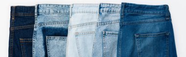 horizontal row of various jeans isolated on white, top view, banner clipart