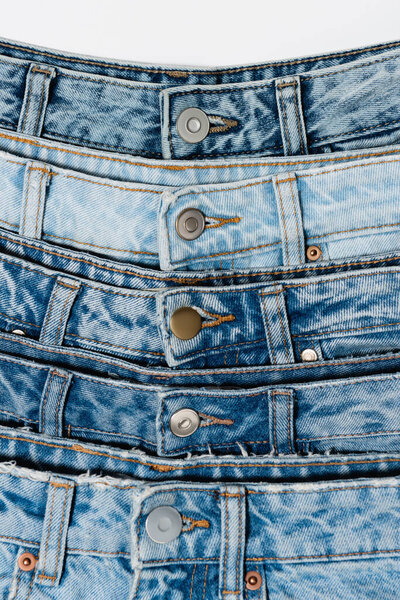 closed up view of various blue jeans isolated on white