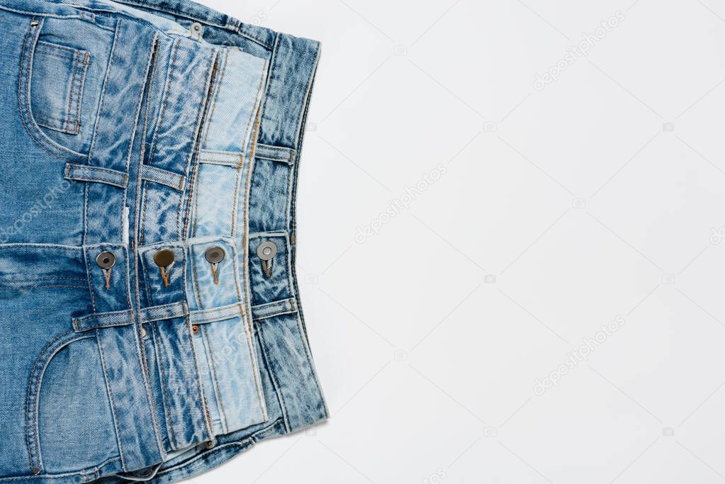 different blue jeans on white background, top view