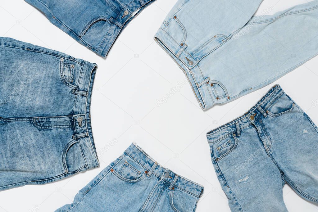 classic blue jeans on white background, top view