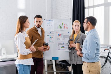 Paket kahve ve dijital tabletle çalışan çok ırklı iş adamları 