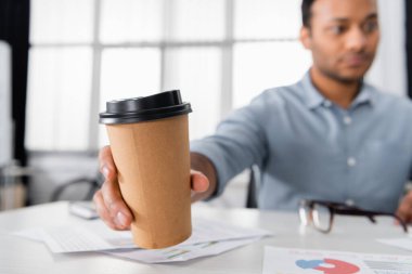 Ofisteki bulanık arka planda Hintli iş adamının eline geçecek kahve. 