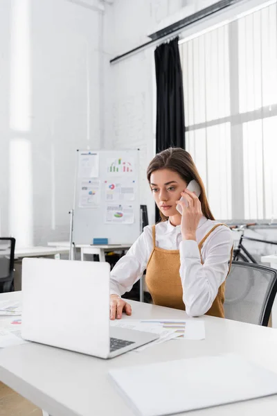 Bizneswoman Rozmawia Smartfonie Pobliżu Laptopa Papiery Zamazanym Pierwszym Planie — Zdjęcie stockowe