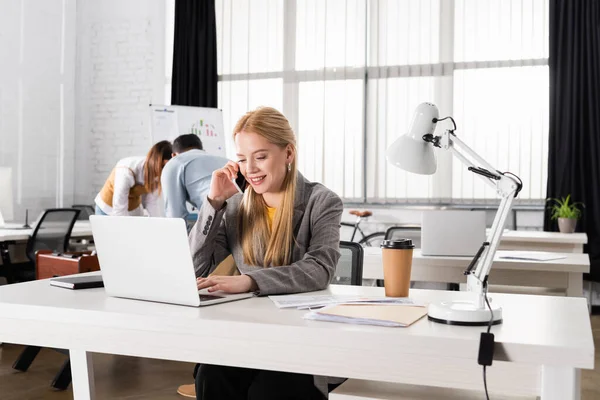 Mujer Negocios Sonriente Hablando Teléfono Inteligente Cerca Computadora Portátil Café — Foto de Stock