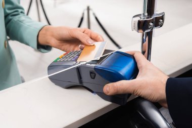 Otelde kredi kartı olan bir kadının yanında müdürün ödeme terminalini tutarken görüntüsü kesilmiş. 
