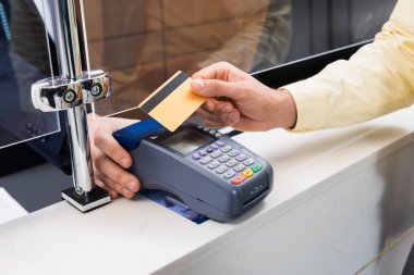 Terminali olan, otel müdürünün yanında kredi kartı tutan adam görüntüsü. 