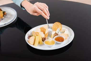 Otel odasında peyniri sosa batıran genç bir kadın manzarası. 