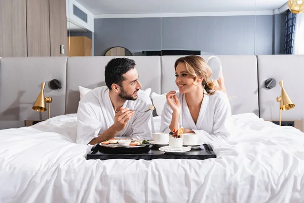 Smiling Interracial Couple Looking Each Other Breakfast Tray Hotel Bed — Stock Photo, Image