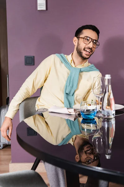 Χαρούμενος Μουσουλμάνος Κάθεται Κοντά Νόστιμο Δείπνο Στο Δωμάτιο Του Ξενοδοχείου — Φωτογραφία Αρχείου