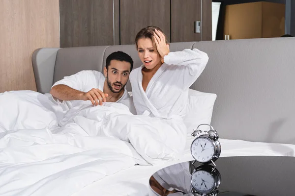 Worried Interracial Couple Bed Alarm Clock Hotel Room — Stock Photo, Image