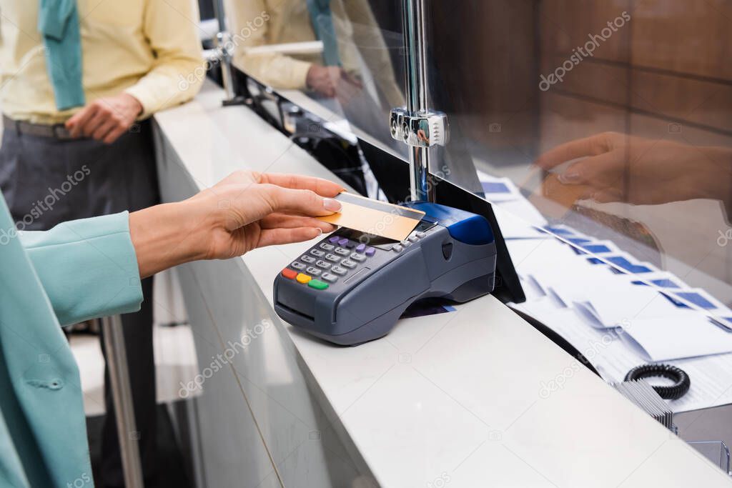 Cropped view of woman paying with credit card on hotel reception 