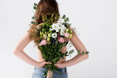 Gri renkli çiçekleri tutan kot pantolonlu modelin arka planı 