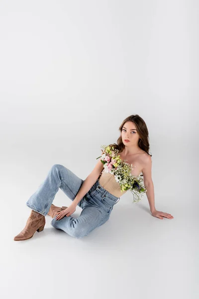 Brunette Woman Flowers Blouse Looking Camera While Sitting Grey Background — Stock Photo, Image