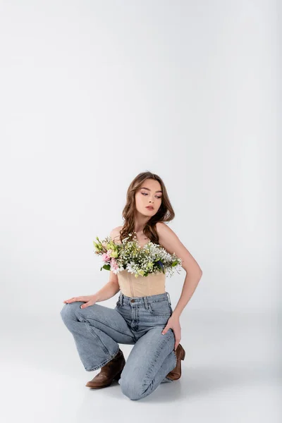 Fiatal Modell Virágok Blúzban Térdelő Szürke Háttér — Stock Fotó