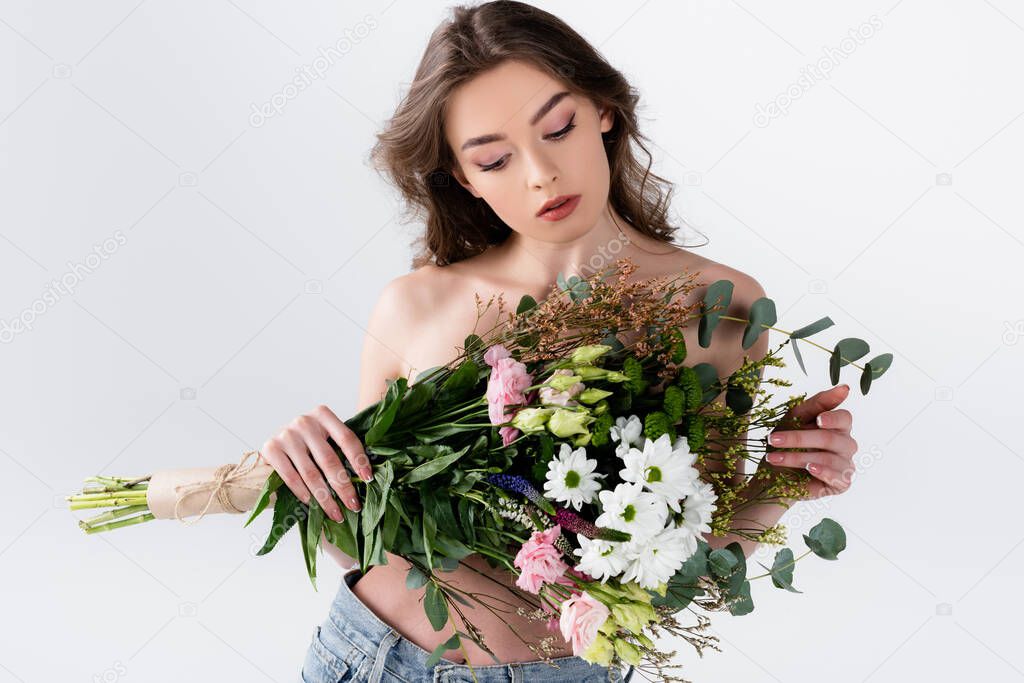 Shirtless model holding floral bouquet isolated on grey 