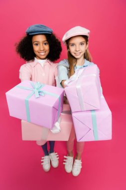 Pembe hediye kutularıyla poz veren modaya uygun ırklar arası kızlar.