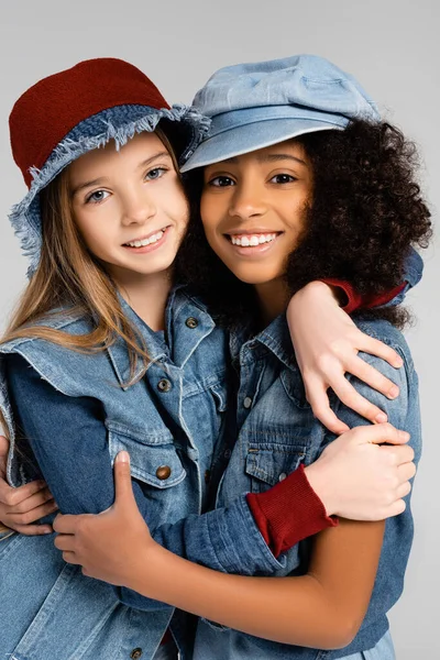 Щасливі Мультикультурні Дівчата Стильному Джинсовому Одязі Обіймаючись Ізольовано Сірому — стокове фото