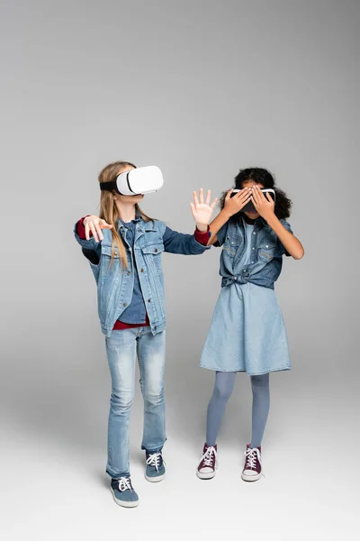 African American Girl Covering Headset While Standing Friend Grey — Stock Photo, Image