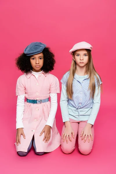 Multicultural Girls Fashionable Clothes Caps Looking Camera While Posing Pink — Stock Photo, Image