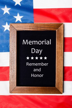 Top view of chalkboard with memorial day remember and honor lettering on american flag  clipart