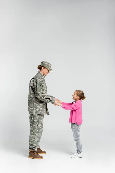 Side View Smiling Soldier Daughter Holding Hands Grey Background — Stock Photo, Image