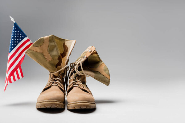 Military boots with american flag on grey background 