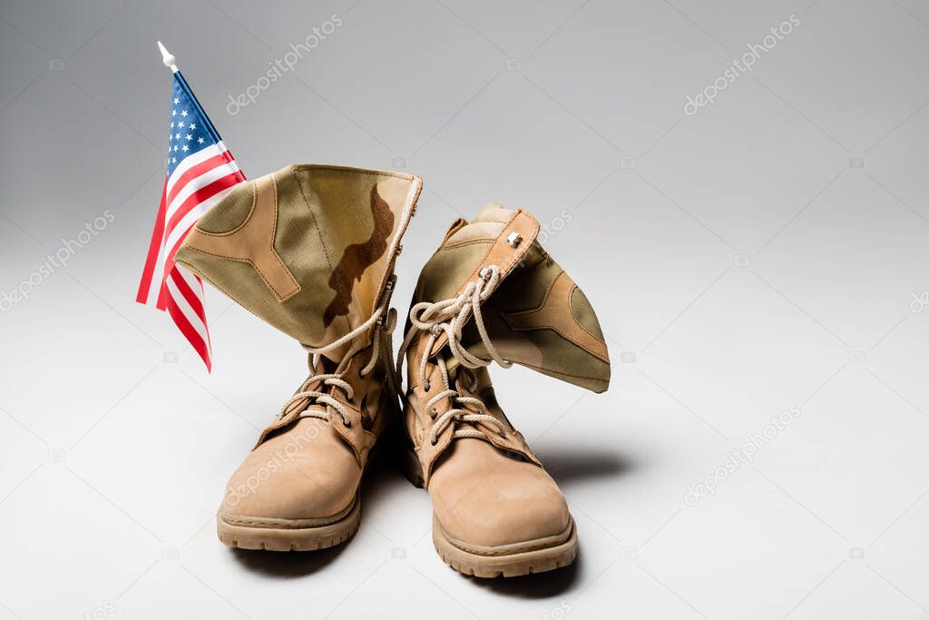 American flag and military boots on grey background 