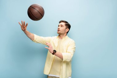 player in yellow shirt throwing basketball on blue clipart