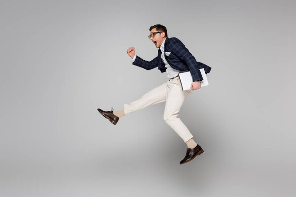 полный рост изумленного бизнесмена, держащего бумажную папку во время полета на сером самолете