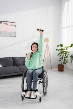 Disabled woman training with dumbbells at home  clipart