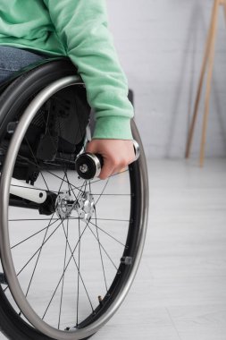Tekerlekli sandalyede elinde dambıl tutan kadın görüntüsü. 