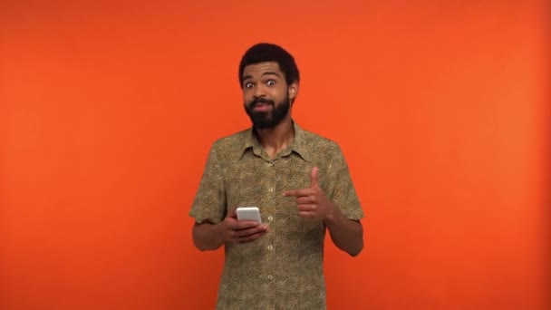 Africano Americano Homem Segurando Smartphone Mostrando Como Isolado Laranja — Vídeo de Stock
