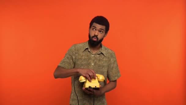 Africano Americano Hombre Hablando Amarillo Retro Teléfono Aislado Naranja — Vídeos de Stock