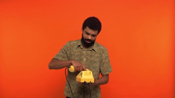 Glad Afrikansk Amerikansk Man Talar Retro Telefon Isolerad Orange — Stockvideo