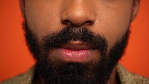 Частковий Вид Бородатого Афроамериканця Лизати Губи Ізольовано Апельсині — стокове відео