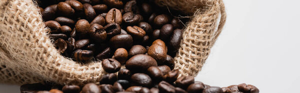 close up of hessian sack bag with roasted coffee beans isolated on white, banner