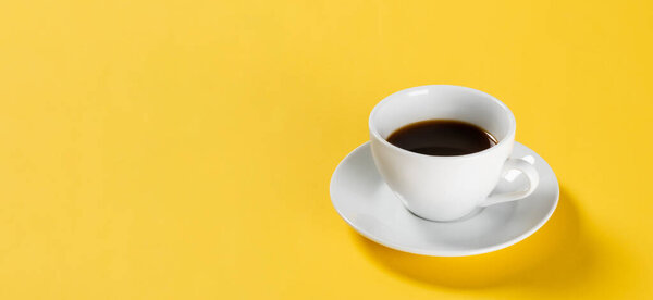 black coffee in white cup on yellow background, banner