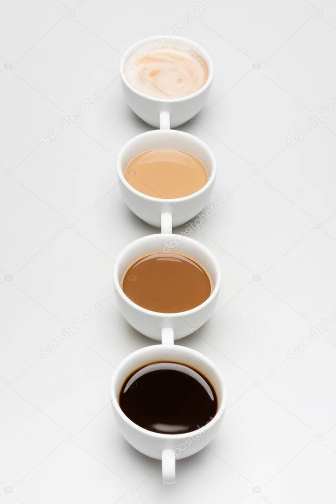 different prepared coffee drinks with milk on white